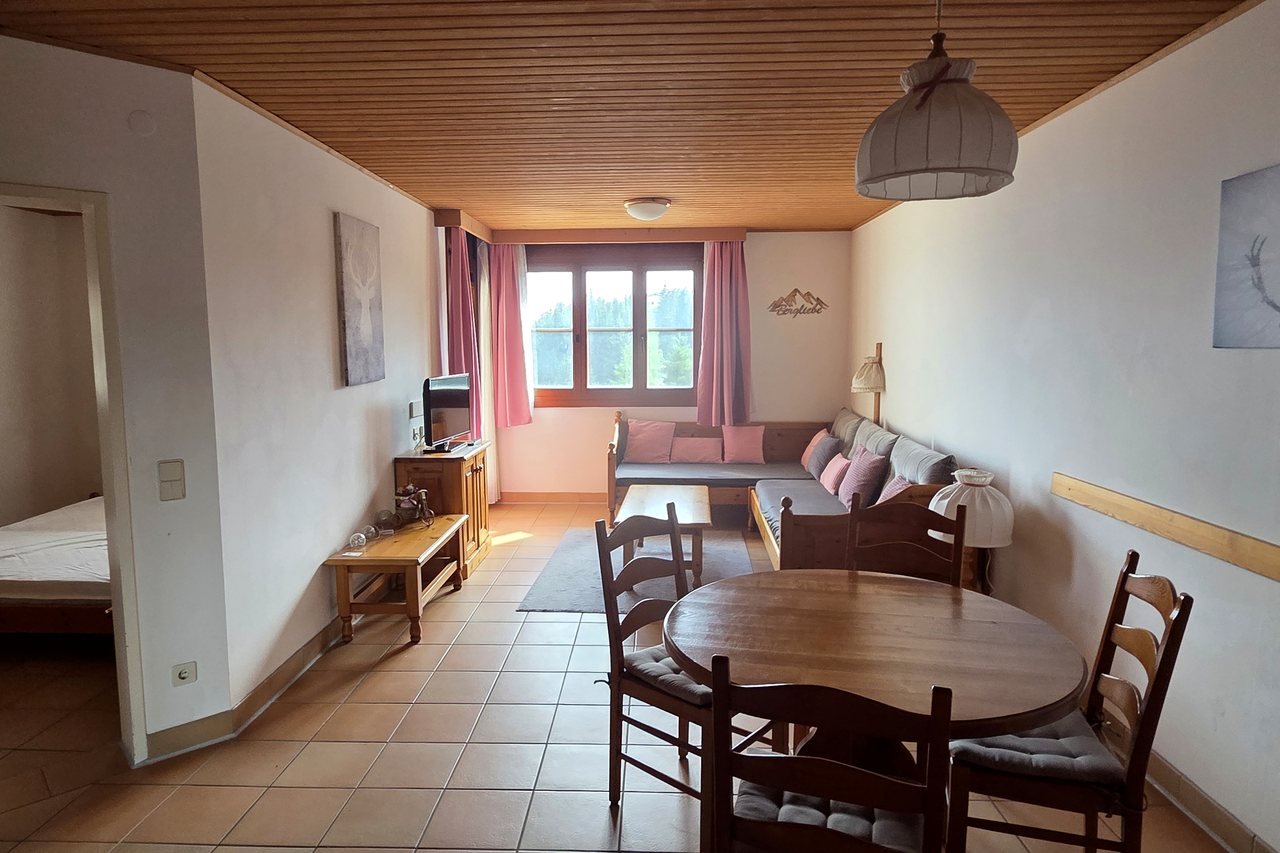 Ferienwohnung Alpenzeit auf der Gerlitzen Alpe – heller Wohnraum mit Esstisch und Sofa