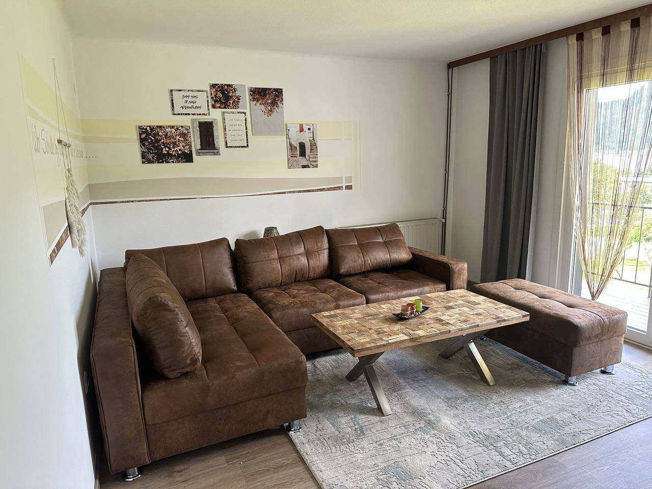 Wohnzimmer mit Ecksofa und Balkontür – Ferienwohnung Ossiachersee (Erdgeschoss), Sattendorf